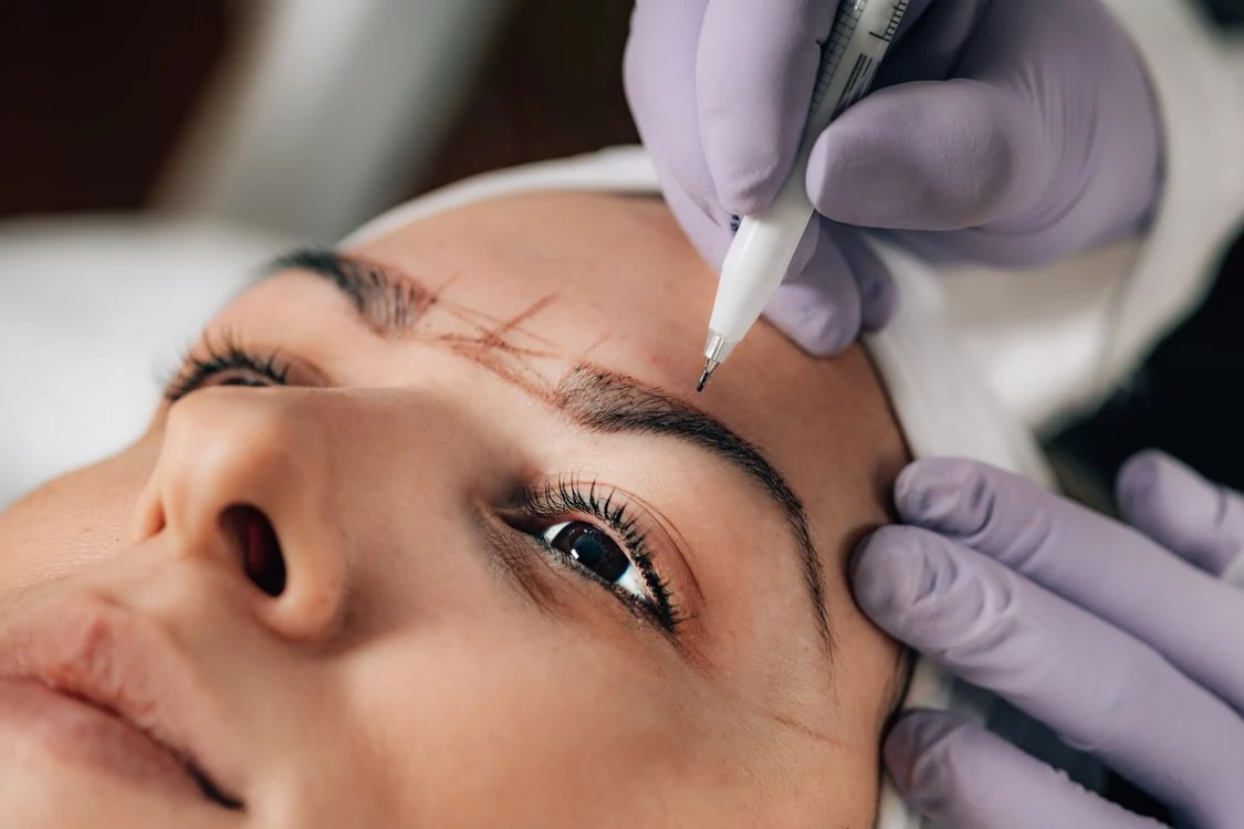 Close-up of a beautician working on an eyebrow tattoo